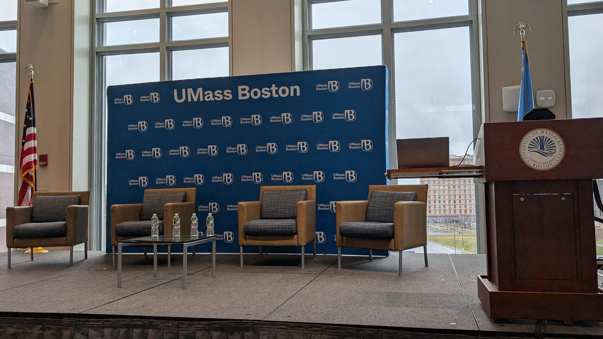 Four chairs up on a stage ready for the speakers of the fireside chat